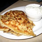 A plate of Afghan Bolani accompanied by a serving of sour cream
